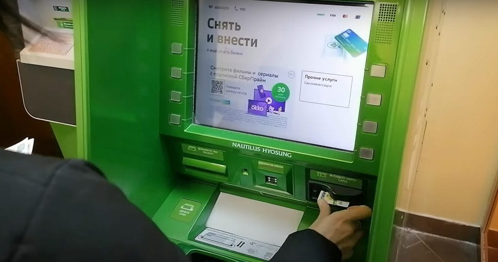 A Russian man uses a Mir card at a Sberbank ATM.