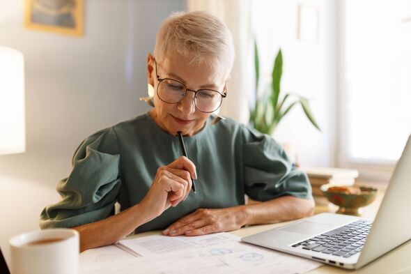 Elderly woman in glasses examining document