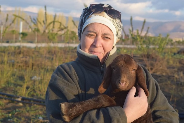 Iffat Rachid Edriss poses with a goat on one of her environmental campaigns. Her organisation used to be self-sufficient, but she now finds herself in Samarkand lobbying for funds to clean up the environment now littered with ordnance from the conflict affecting Lebanon. Credit: Iffat Rachid Edriss