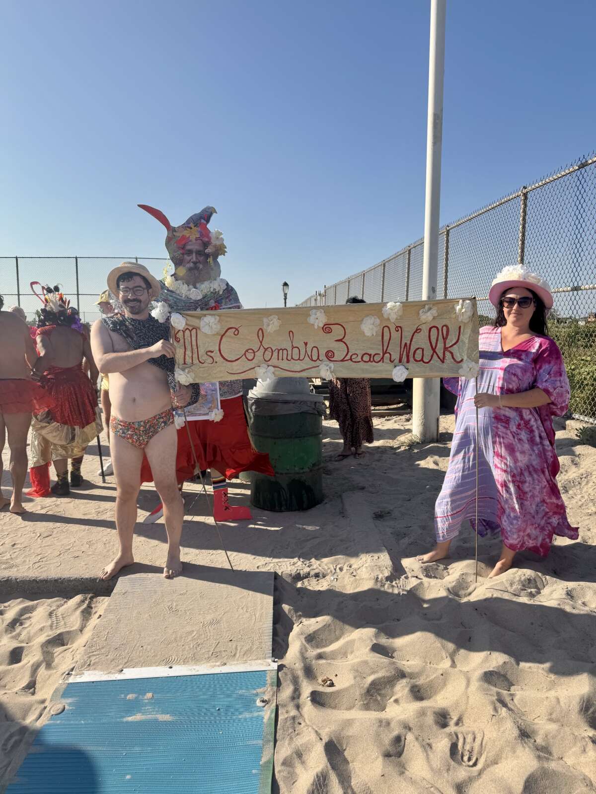 Participants in the Miss Colombia Day celebration line up at Jacob Riis Beach on August 9, 2025, before parading down the shore to honor Miss Colombia, who made the beach her home for decades.