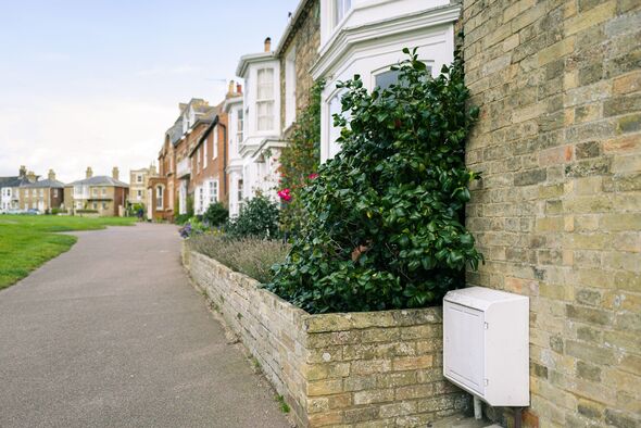 Shallow focus of an external gas mains enclose box seen outside an end of terraced house .