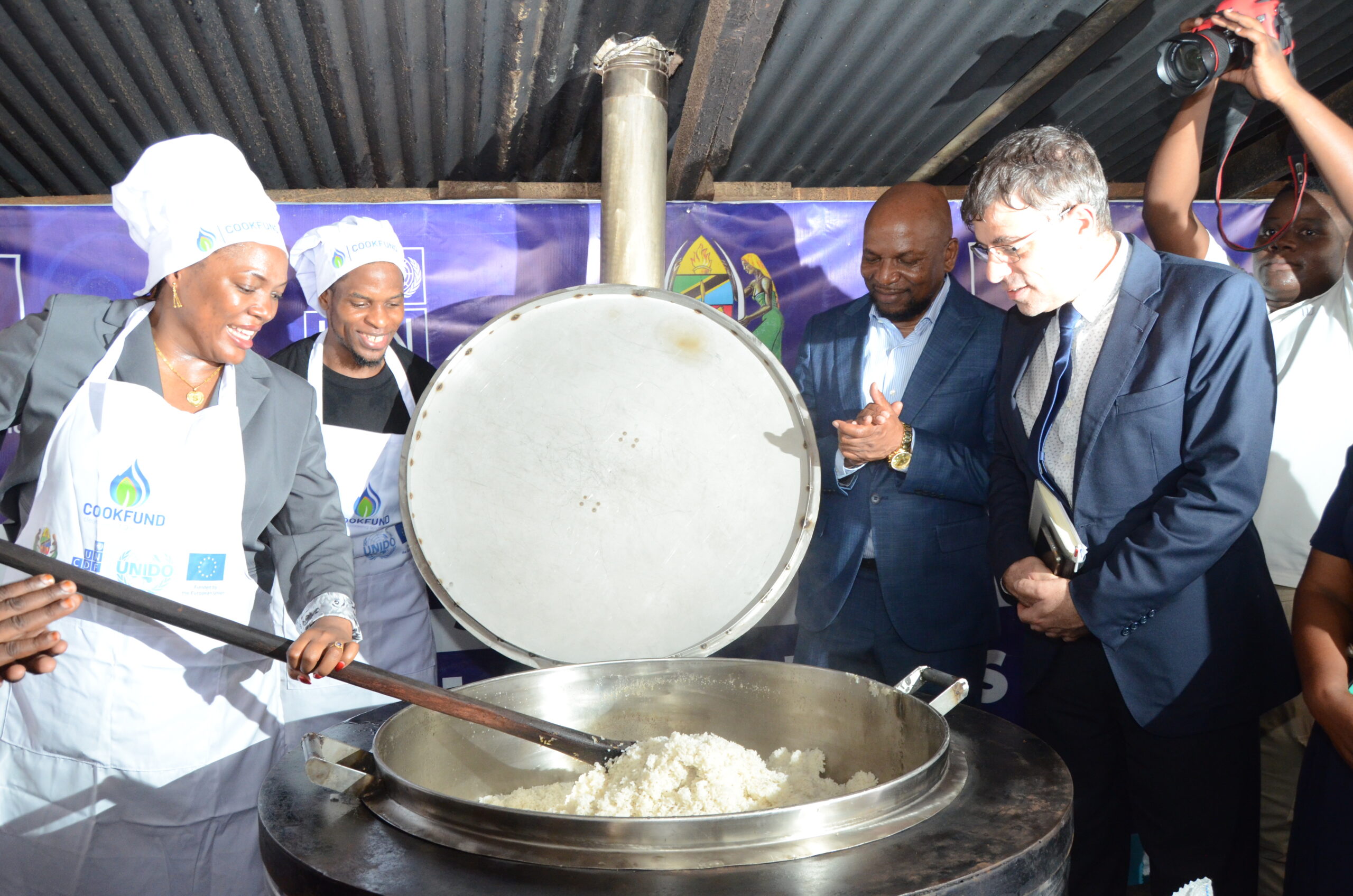 Salome Makamba, deputy minister for energy, cooks lunch using a clean-energy stove installed through the EU-funded CookFund programme in Tanzania. The initiative has equipped more than 45 public institutions with modern cooking technologies, benefiting over 62,000 students while reducing reliance on firewood and charcoal. As the European Parliament questions aspects of future EU engagement with Tanzania, projects such as CookFund have become a reminder of the development gains at stake, including improved health, reduced deforestation and expanded access to clean energy for schools and communities. Credit: UNCDF/CookFund