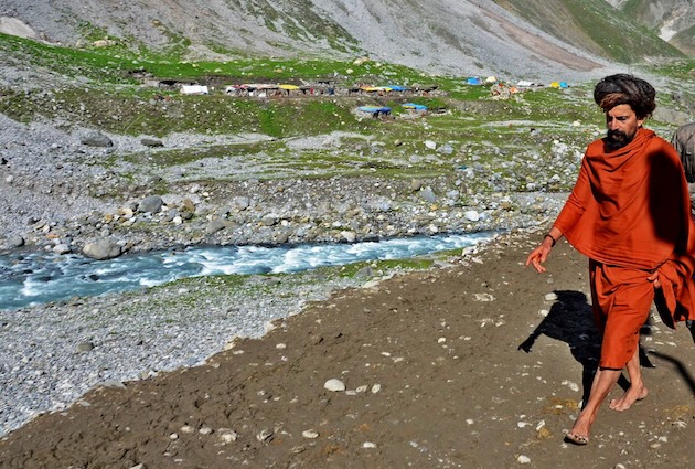 A pilgrim walks to the ancient cave temple which is dedicated to Lord Shiva, a revered Hindu deity. Hindus believe the cave is where Lord Shiva revealed the secret of immortality to his consort Parvati. Credit: Umar Manzoor Shah/IPS