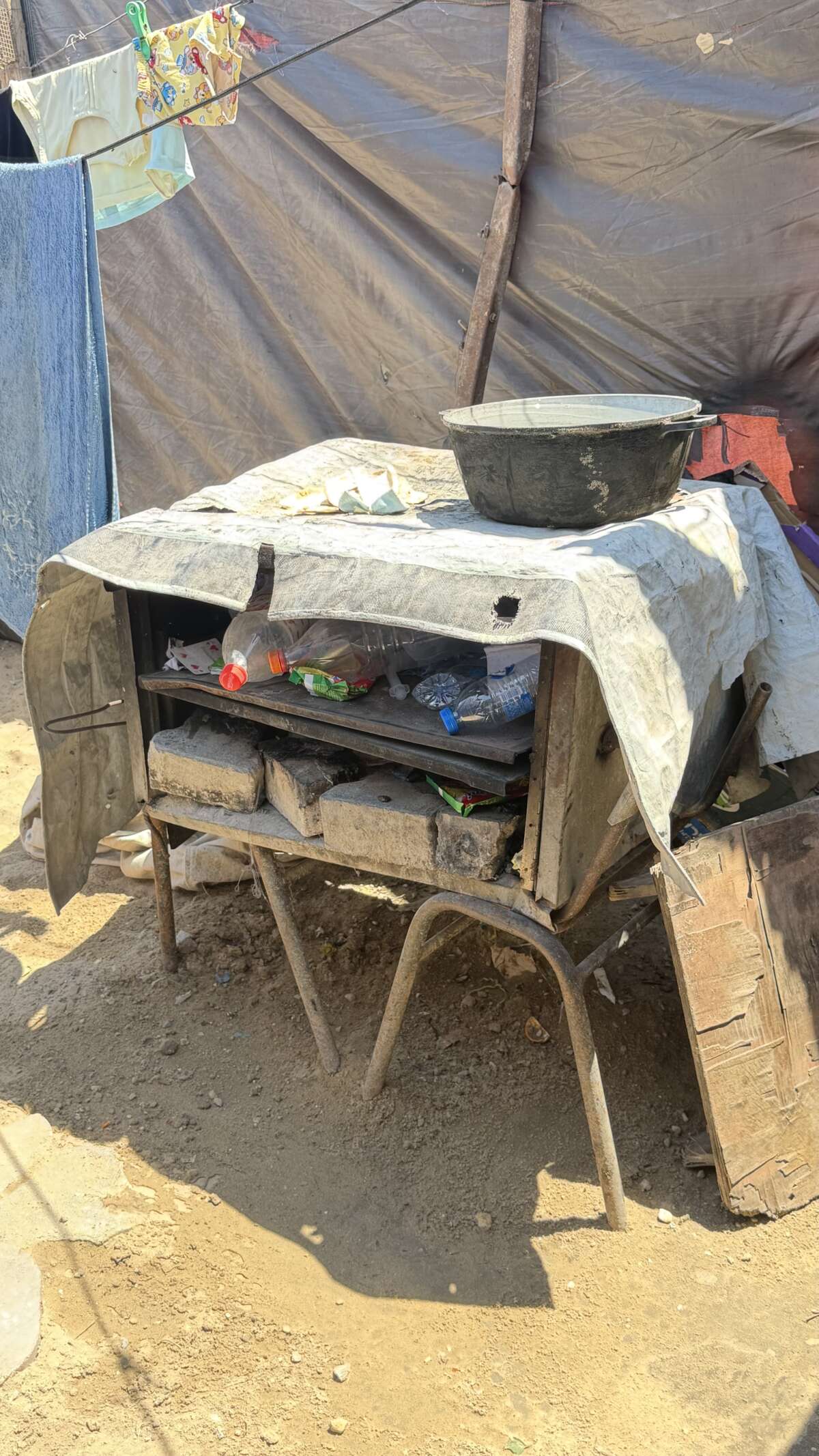 Mowafaq Al-Danaf, 33, bakes bread for his family and neighbors using plastic trash for fuel under the harsh sun in the Al-Awda camp in the west of Gaza, leaving his eyes severely inflamed from the toxic smoke and intense heat.