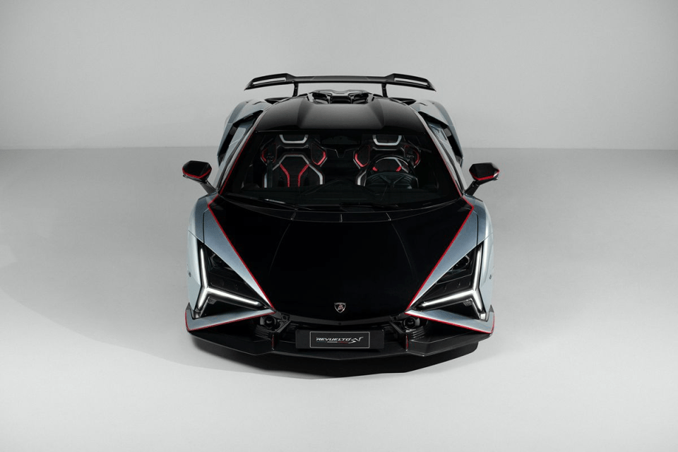 Front view of a sleek, futuristic silver and black sports car with red accents and LED headlights.
