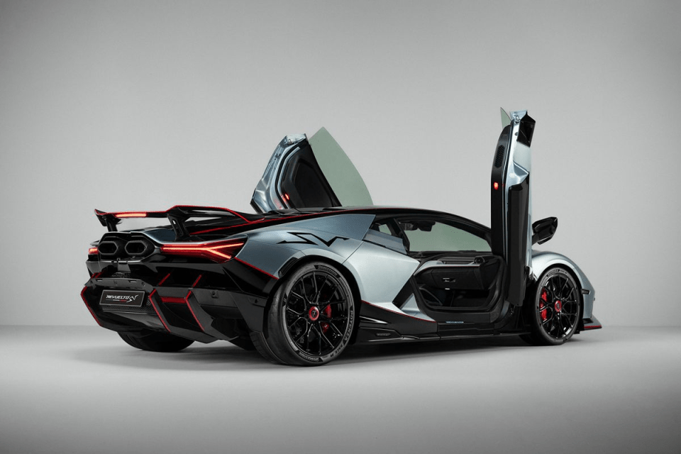 Sleek grey and black Lamborghini Revuelto SV with red accents, rear view, and scissor doors open, showcasing design.