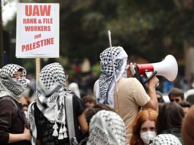 Pro-Palestinian protestors gather with a sign reading 'UAW Rank-and-File Workers For Palestine' after police cleared a new encampment of pro-Palestinian protestors on the UCLA (University of California, Los Angeles) campus on May 23, 2024 in Los Angeles, California.