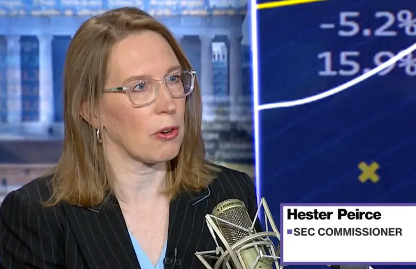 SEC Commissioner Hester Peirce speaking during a televised interview with a microphone in the foreground.