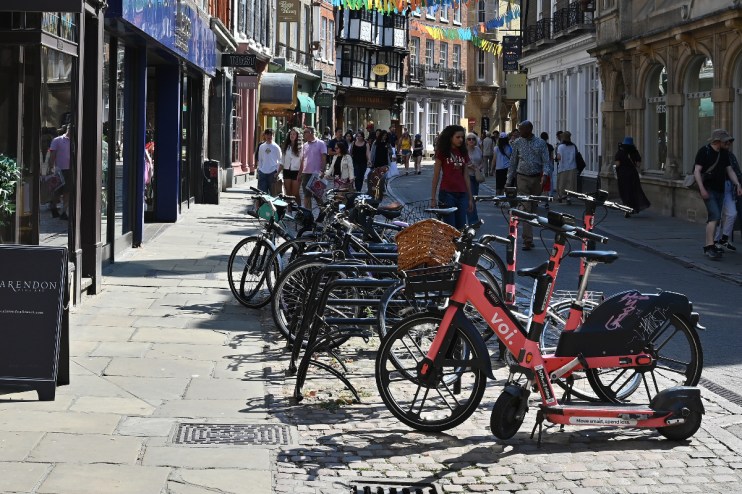 Voi electric scooters lined up on a city street, highlighting urban mobility solutions and eco-friendly transportation opt...