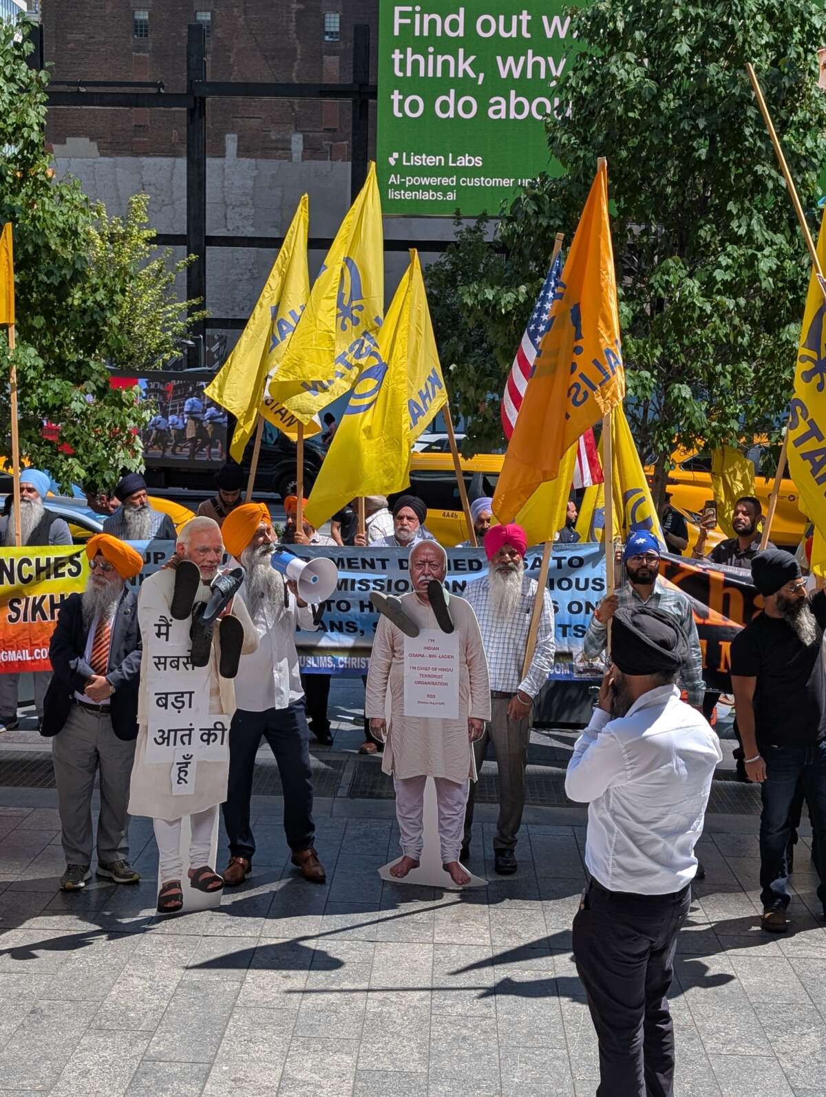 Protesters hang garlands of shoes around effigies of Narendra Modi (left) and Mohan Bhagwat (right).