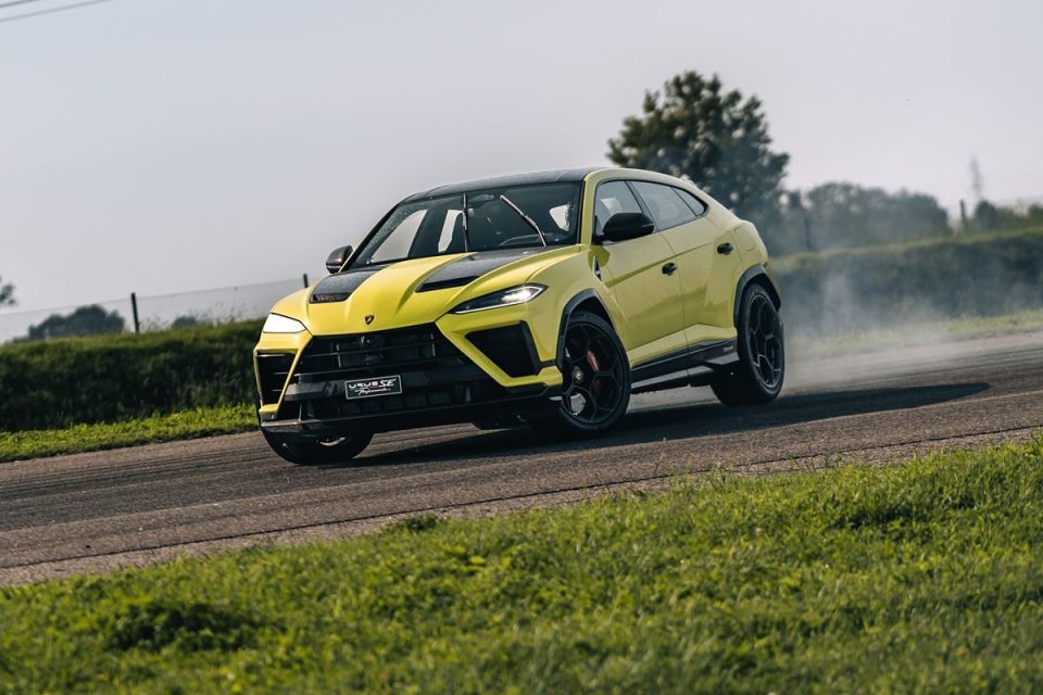 Yellow Lamborghini Urus SE Performance SUV drifting on a track with smoke from its tires.