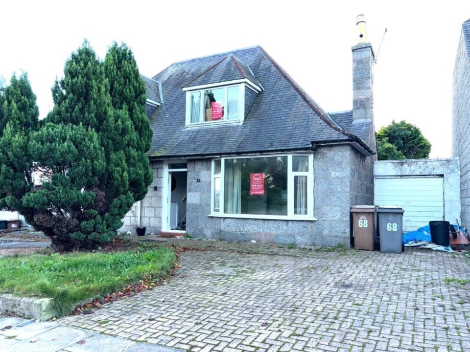 Aberdeen house with granite facade, slate roof, dormer window, For Sale signs, driveway, and garage.
